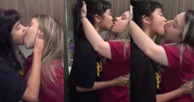 In a pool hall, 2 girls kiss passionately in front of their friends